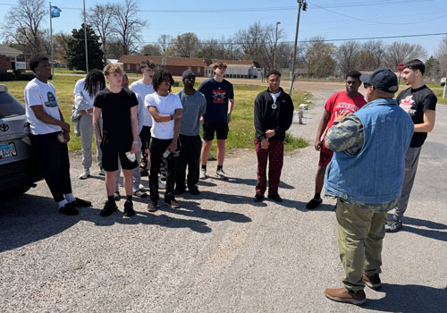 Group of youth services men and boys listening to a speaker during a spring break trip to Mound Bayou.