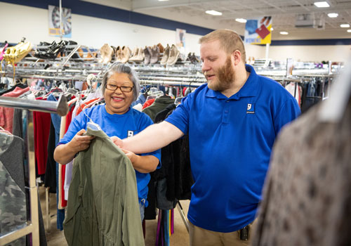 Volunteers LLGI Goodwill employees and volunteer mark clothes with pricing in store.